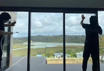 Two technicians at Mr Tint was installing window film for a house glass.