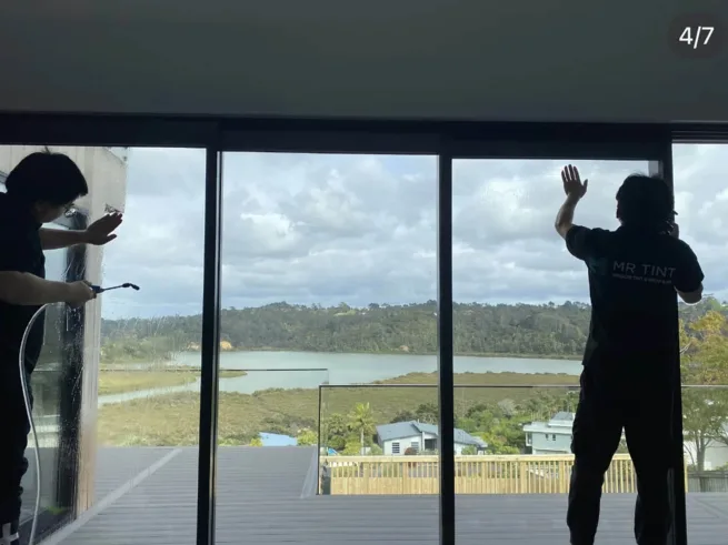 Two technicians at Mr Tint was installing window film for a house glass.